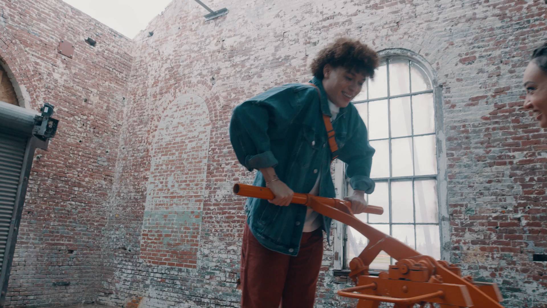 a man in a blue coat pushing down on the handle of a railroad pump car