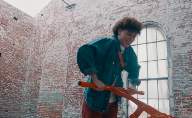 a man in a blue coat pushing down on the handle of a railroad pump car