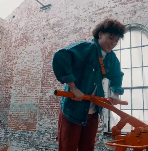 a man in a blue coat pushing down on the handle of a railroad pump car