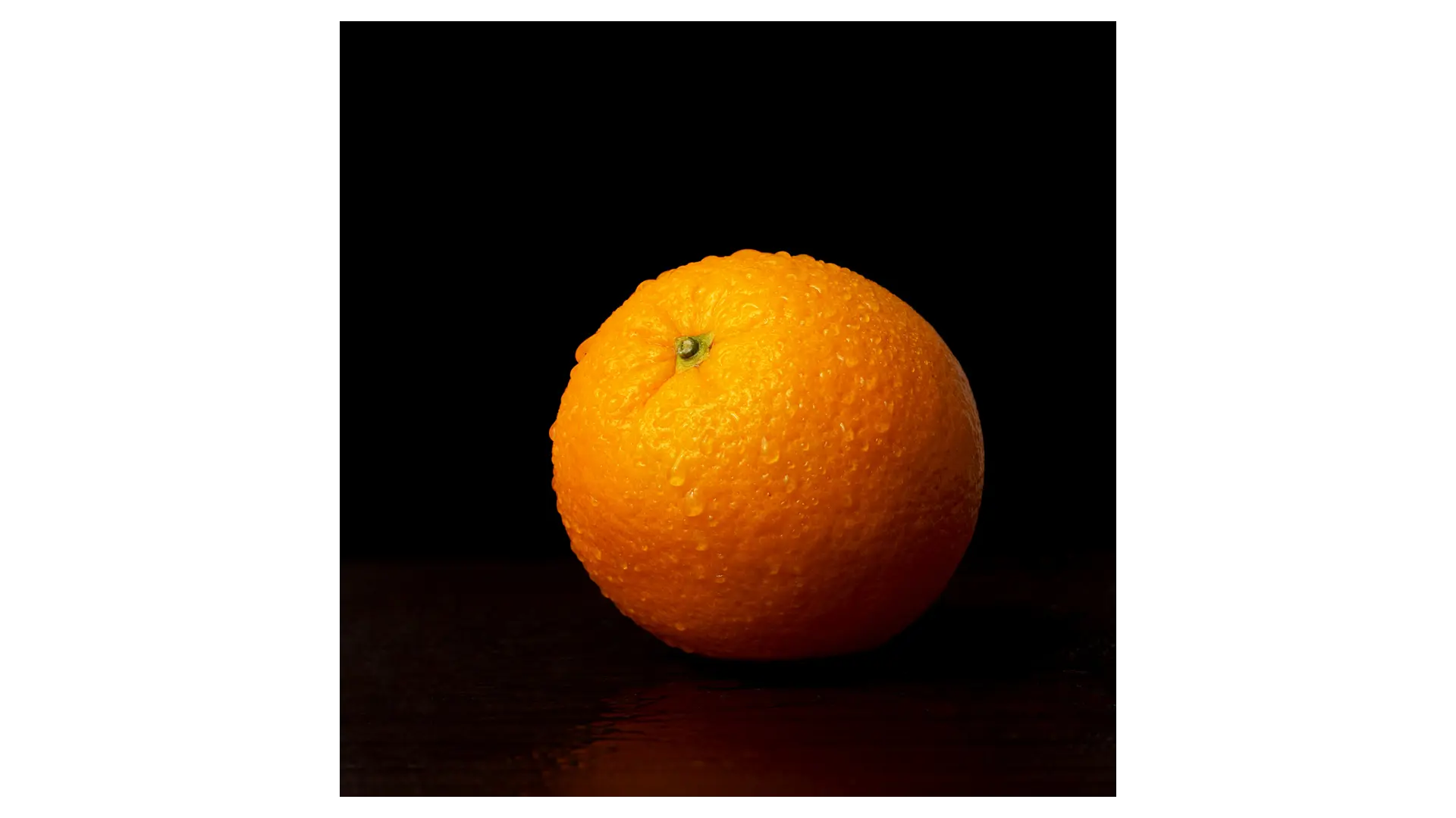 an image of an orange with drops of mouisture on it