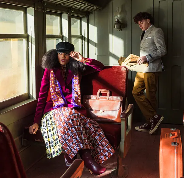 two well-dressed people, a man and woman, inside an old traincar