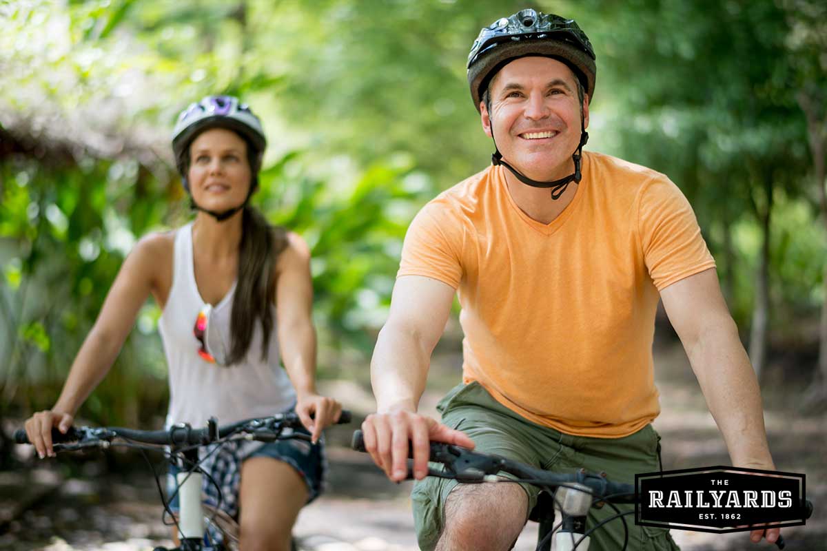 A couple biking in Sacramento. Discover 5 ways to celebrate bike month in Sacramento at the Railyards.com