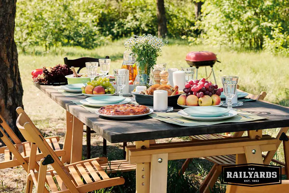 A picnic table with food in a beautiful park.