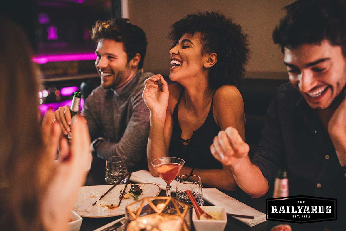 A group of friends talking and laughing at a restaurant. Learn more about Sacramento's reopening.